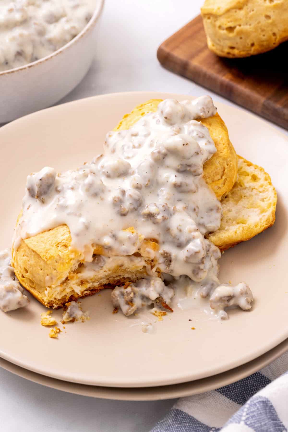 plate of buscuits and sausage gravy sausage gravy poured on top of biscuits.