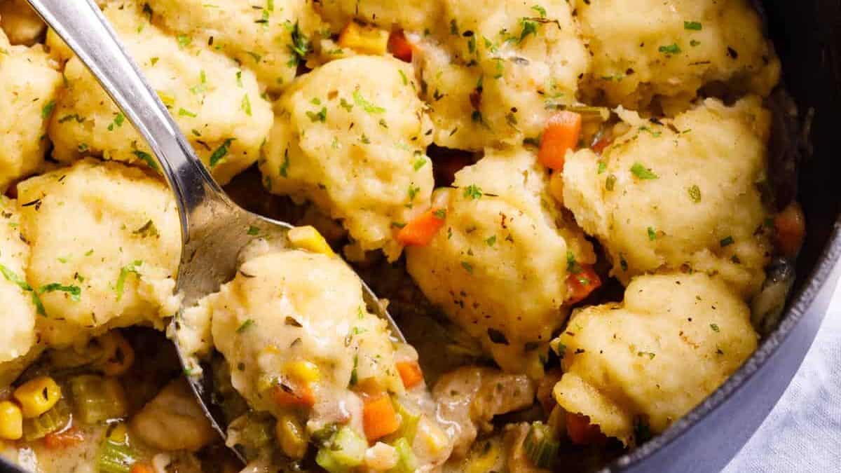 Easy chicken & dumplings in a pot being lifted with a spoon.