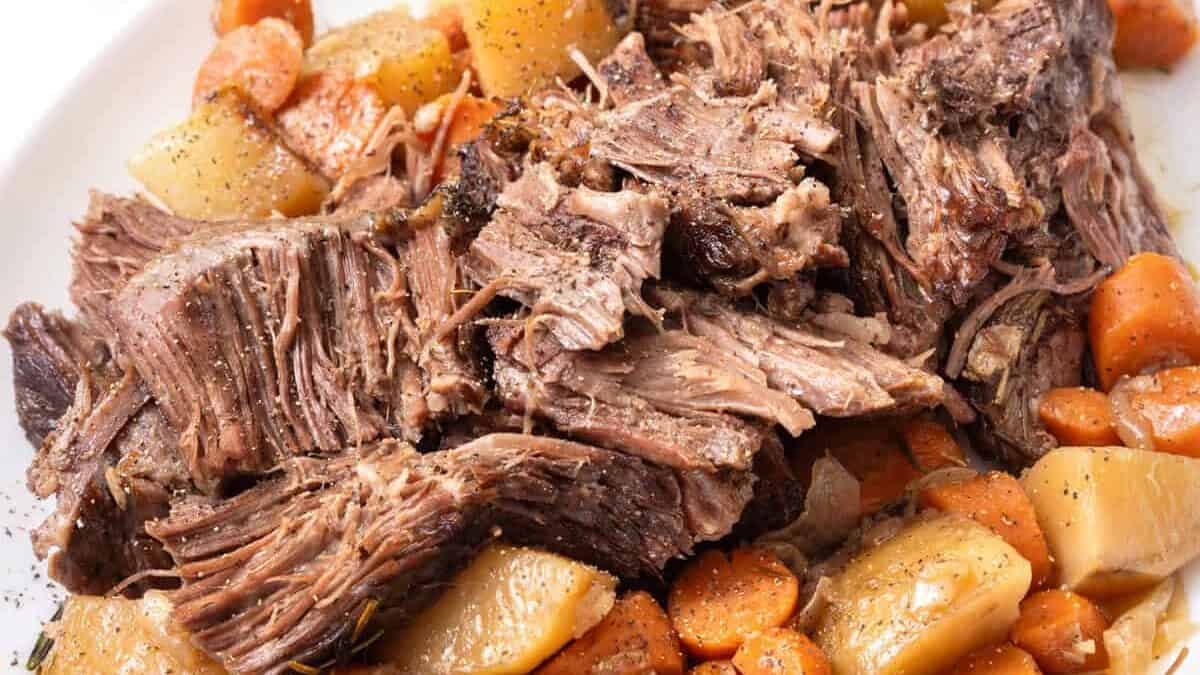 pot roast with vegetables on a white plate.