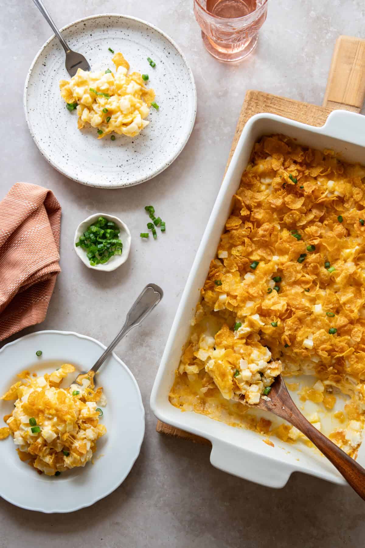 Easy Cheesy Potato Casserole Recipe Overhead view of cheesy potatoes on 2 plates and in baking dish
