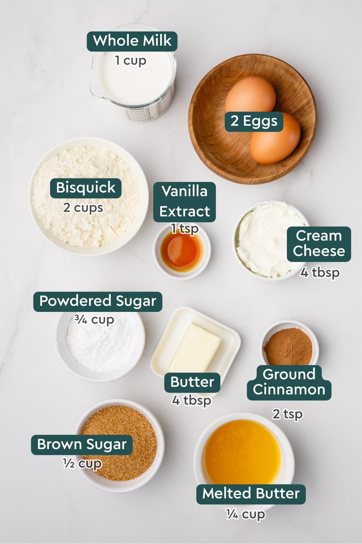 Ingredients for cinnamon roll pancakes, including milk, eggs, bisquick, vanilla, cream cheese, powdered sugar, butter, cinnamon, brown sugar.