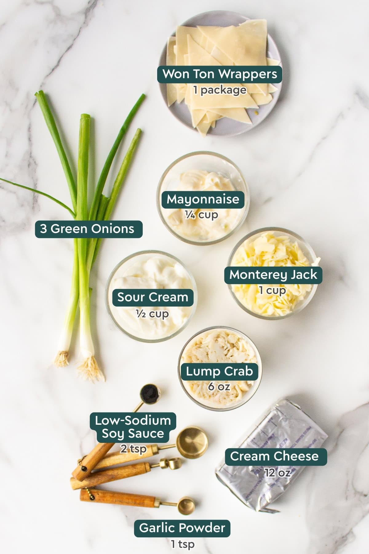 All of the ingredients for crab rangoon dip in bowls on a white countertop.