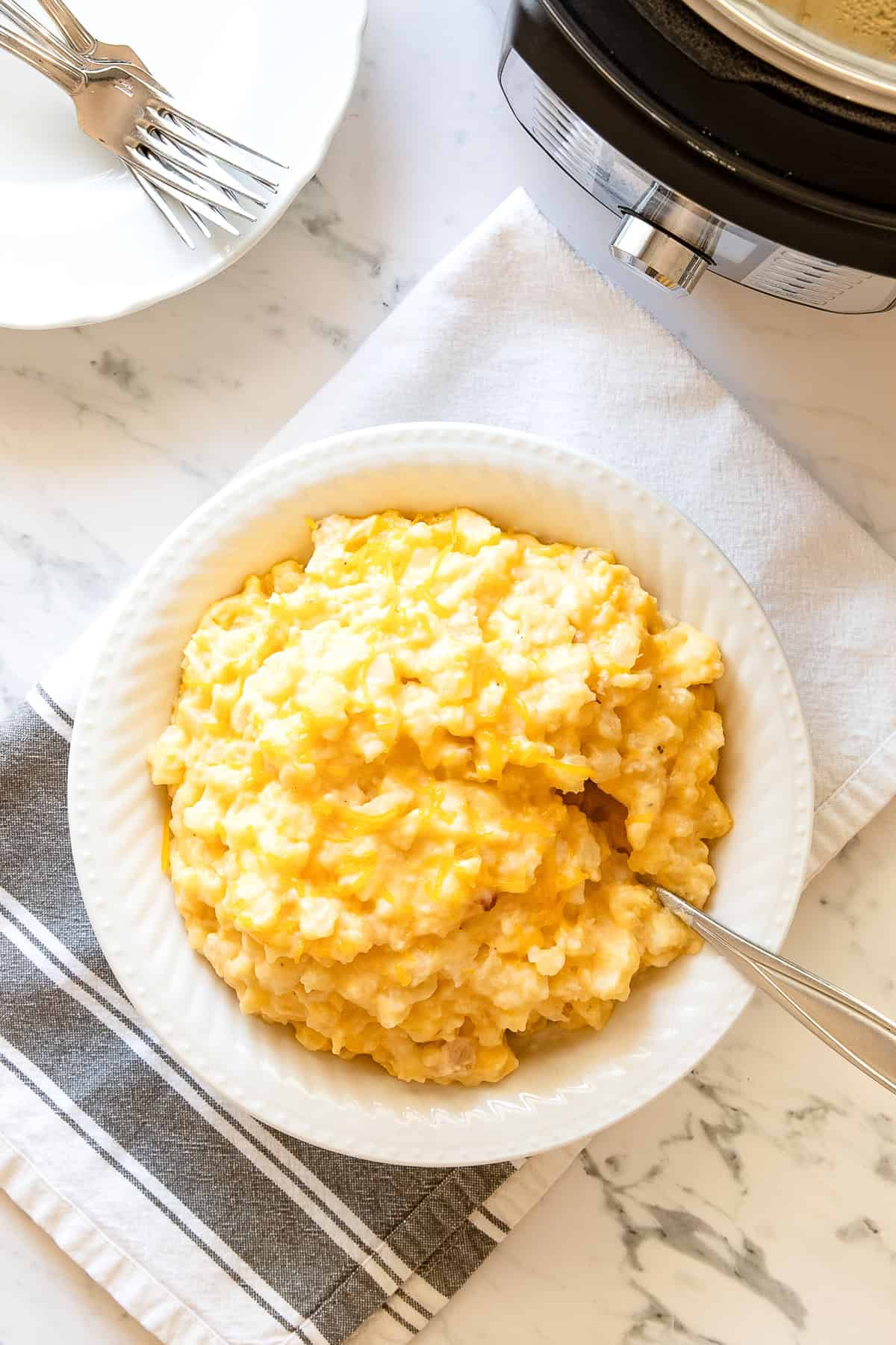 close up image of cheesy potatoes in a crockpot