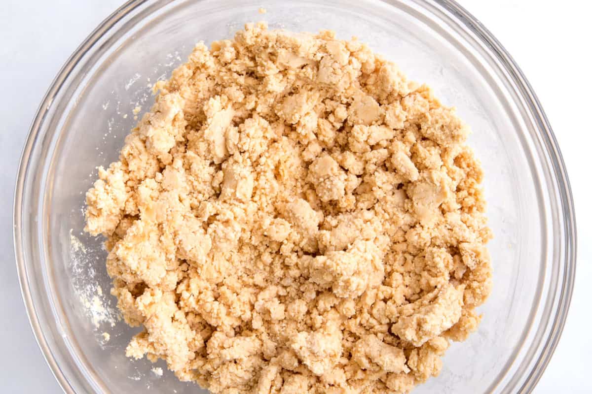 The peanut butter mixture mixed together with the powdered sugar in a glass bowl. It looks drier and has some clumps.