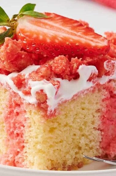 A slice of strawberry crunch poke cake on a plate.