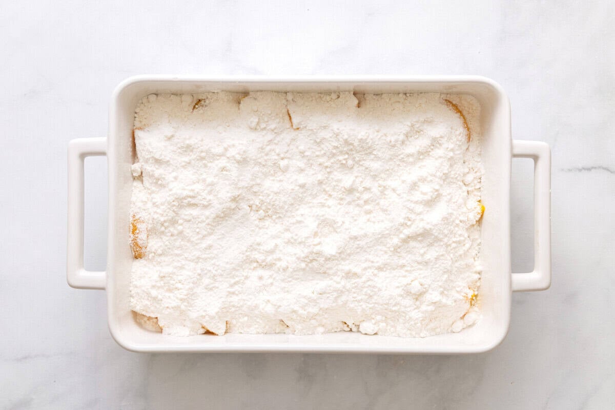 Baking dish with peaches and cake mix.