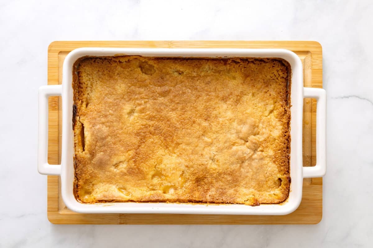 Peach cobbler with cake mix in baking dish.
