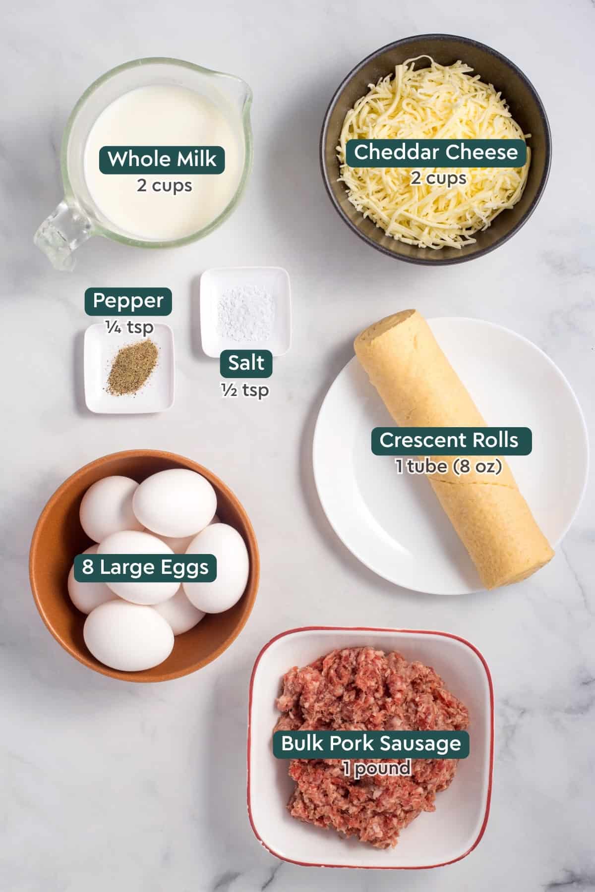 Ingredients for sausage and crescent roll casserole, including whole milk, cheddar, crescent rolls, eggs, sausage, salt, pepper