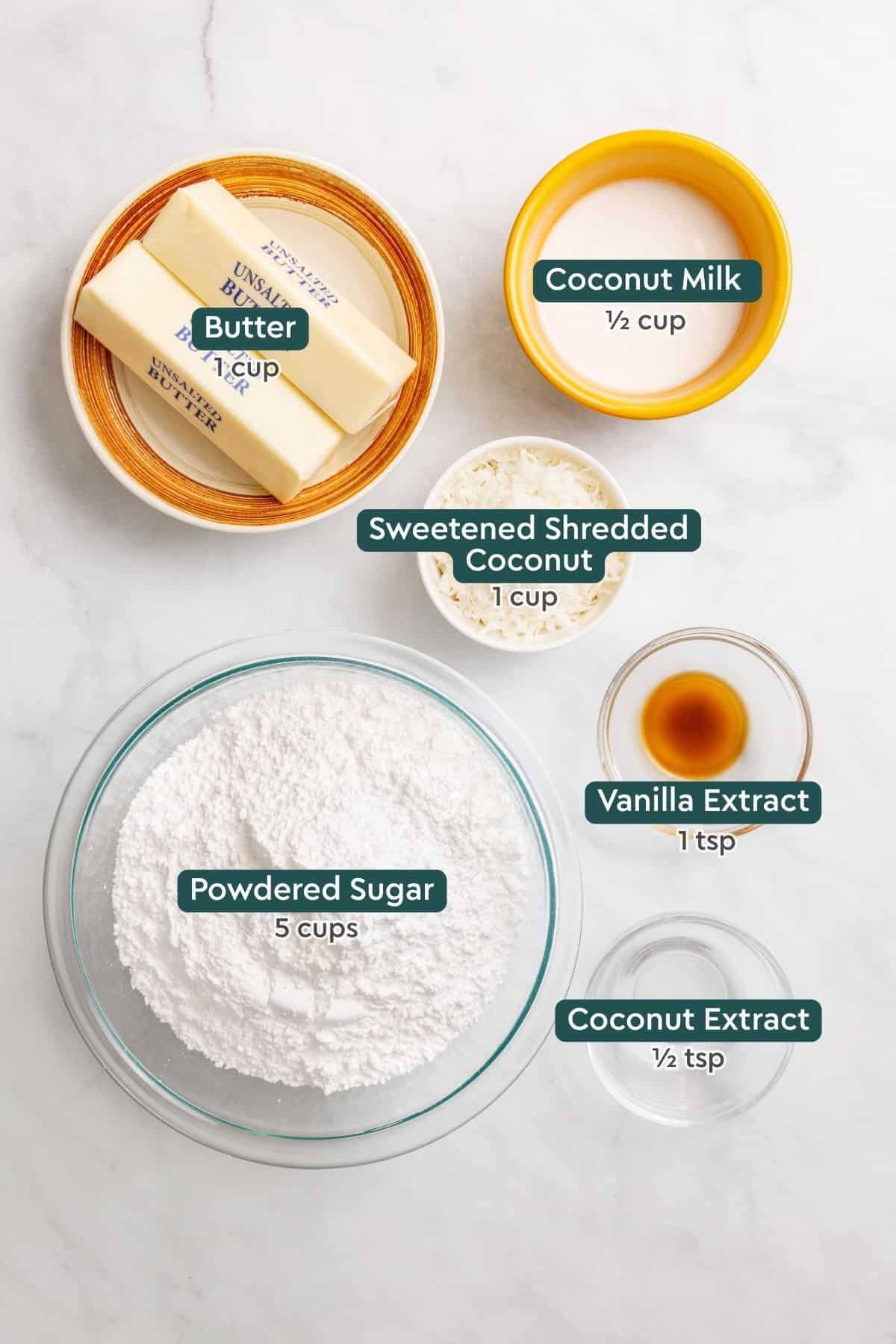 Ingredients for coconut frosting, including butter, coconut milk, shredded coconut, vanilla, powdered sugar, coconut extract.