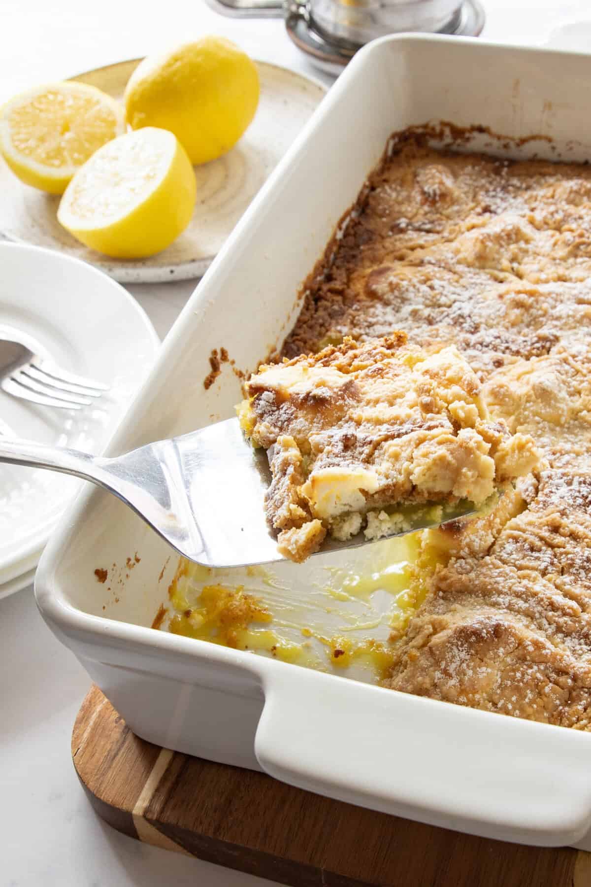 lemon dump cake with cream cheese lemon cream cheese dump cake with slice being removed.