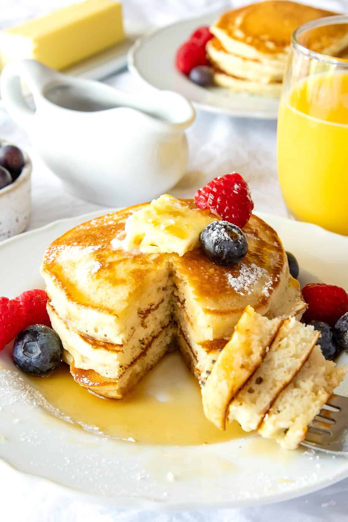 pancakes on a plate with a bite on a fork