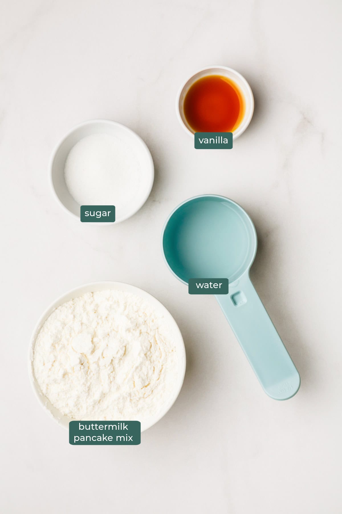 The ingredients for funnel cakes made with pancake mix in bowls on a countertop.