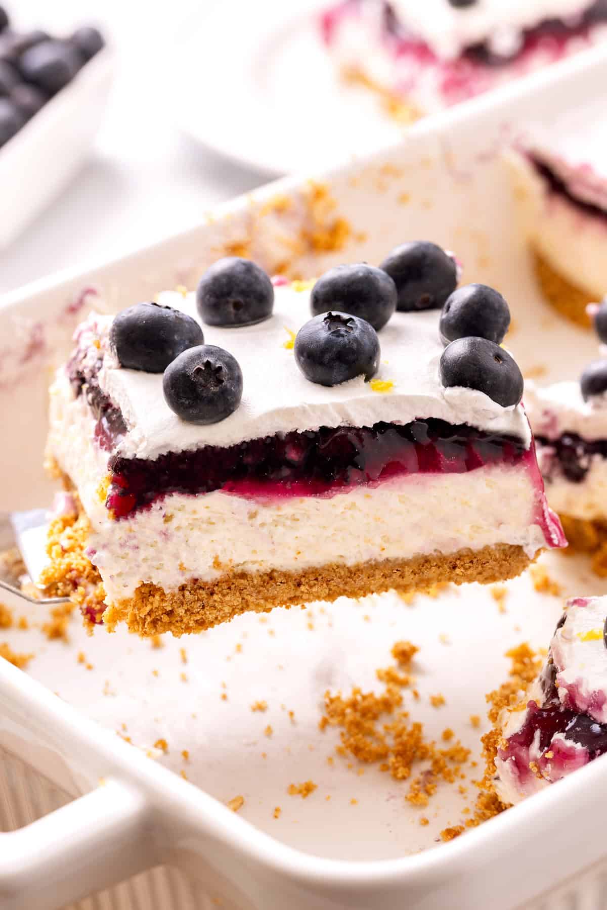 Slice of lemon blueberry delight being lifted from baking dish