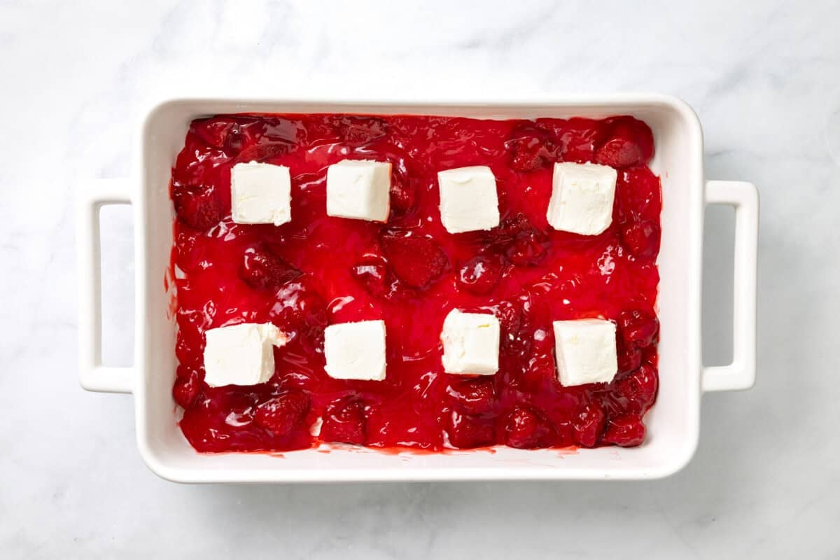 Cream cheese added to pan of strawberry pie filling.