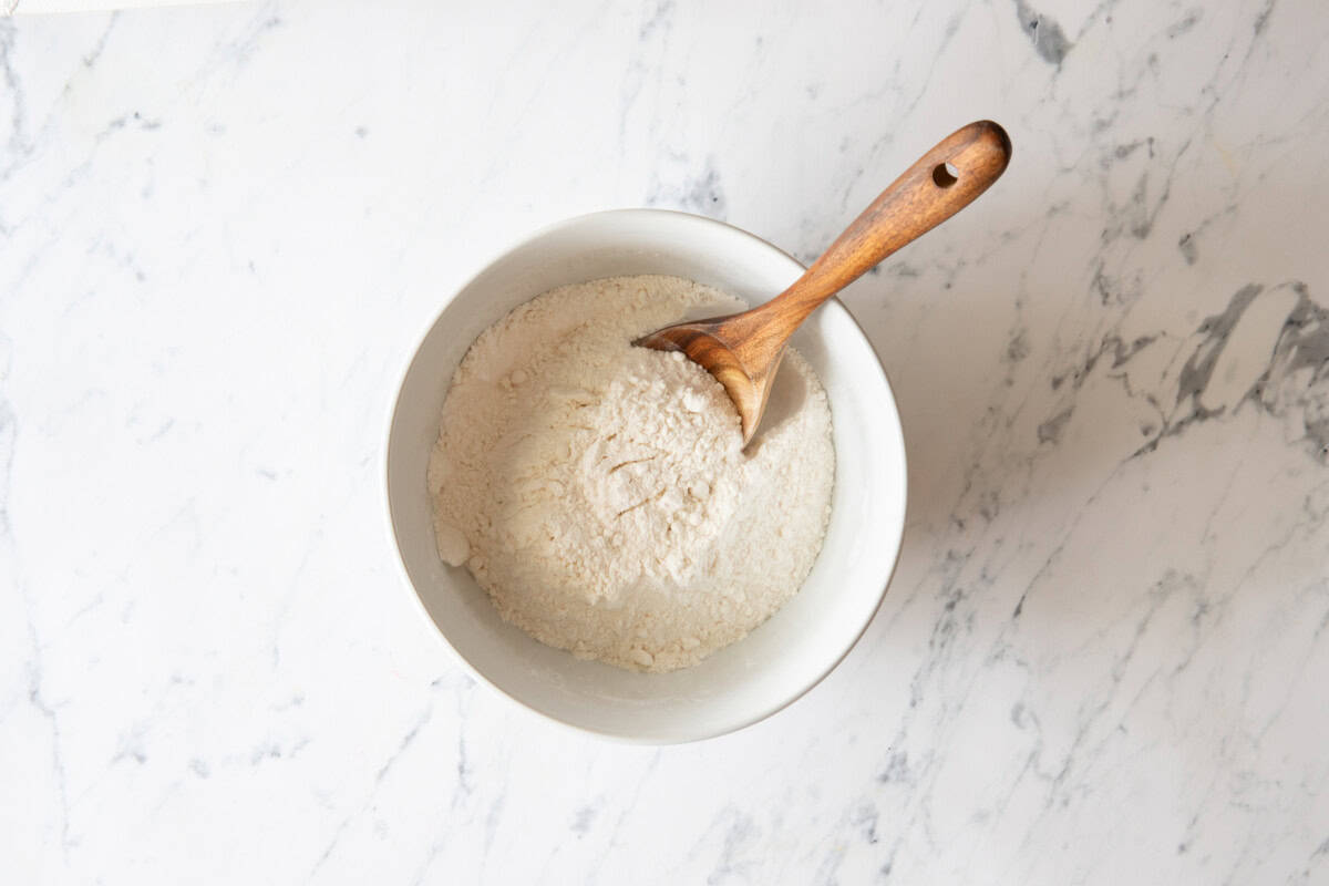 Pudding and cake mix in bowl with wooden spoon.