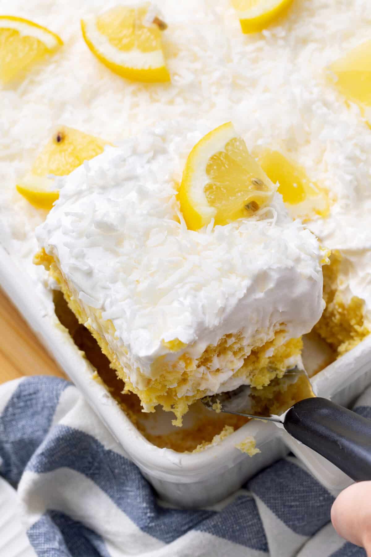 lemon coconut poke cake with lemon slice on top. 
