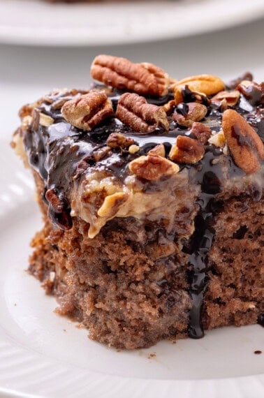 german chocolate poke can with chocolate drizzle and pecan topping.