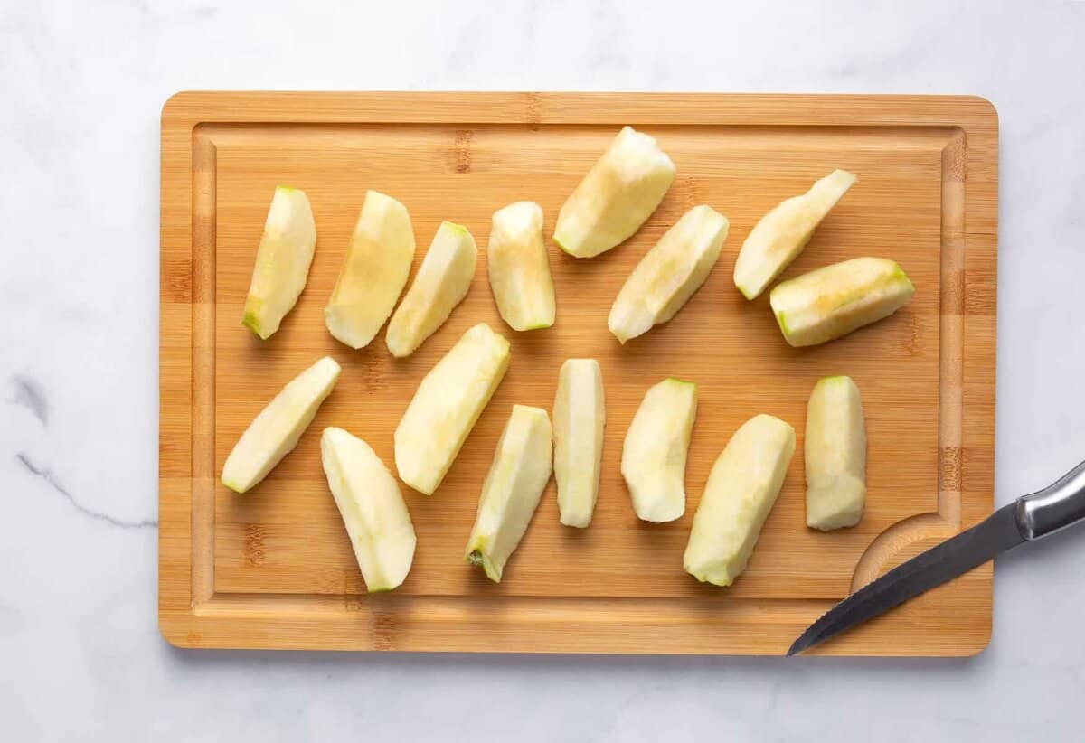 Thick slices of apple on cutting board.