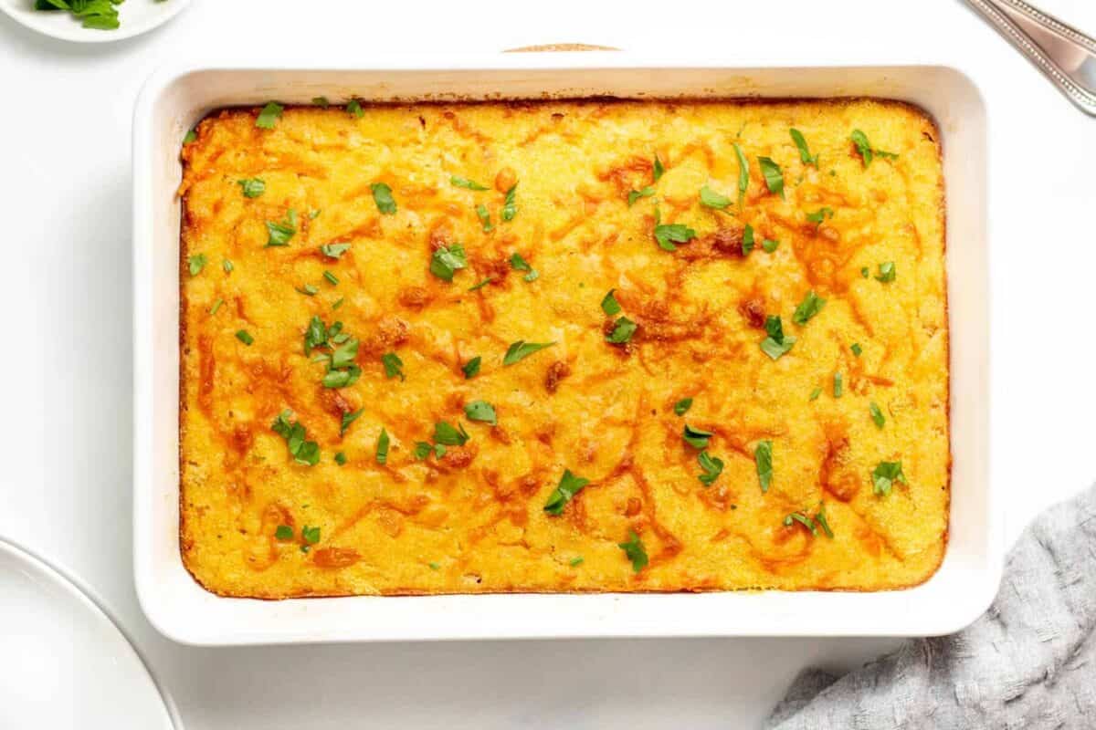 Baked cheesy cornbread casserole in dish.