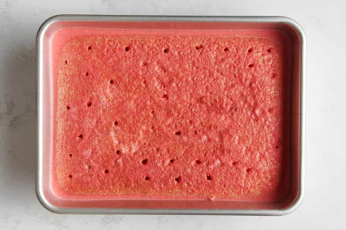 Baked cake in 9x13 pan soaked with strawberry jello. 