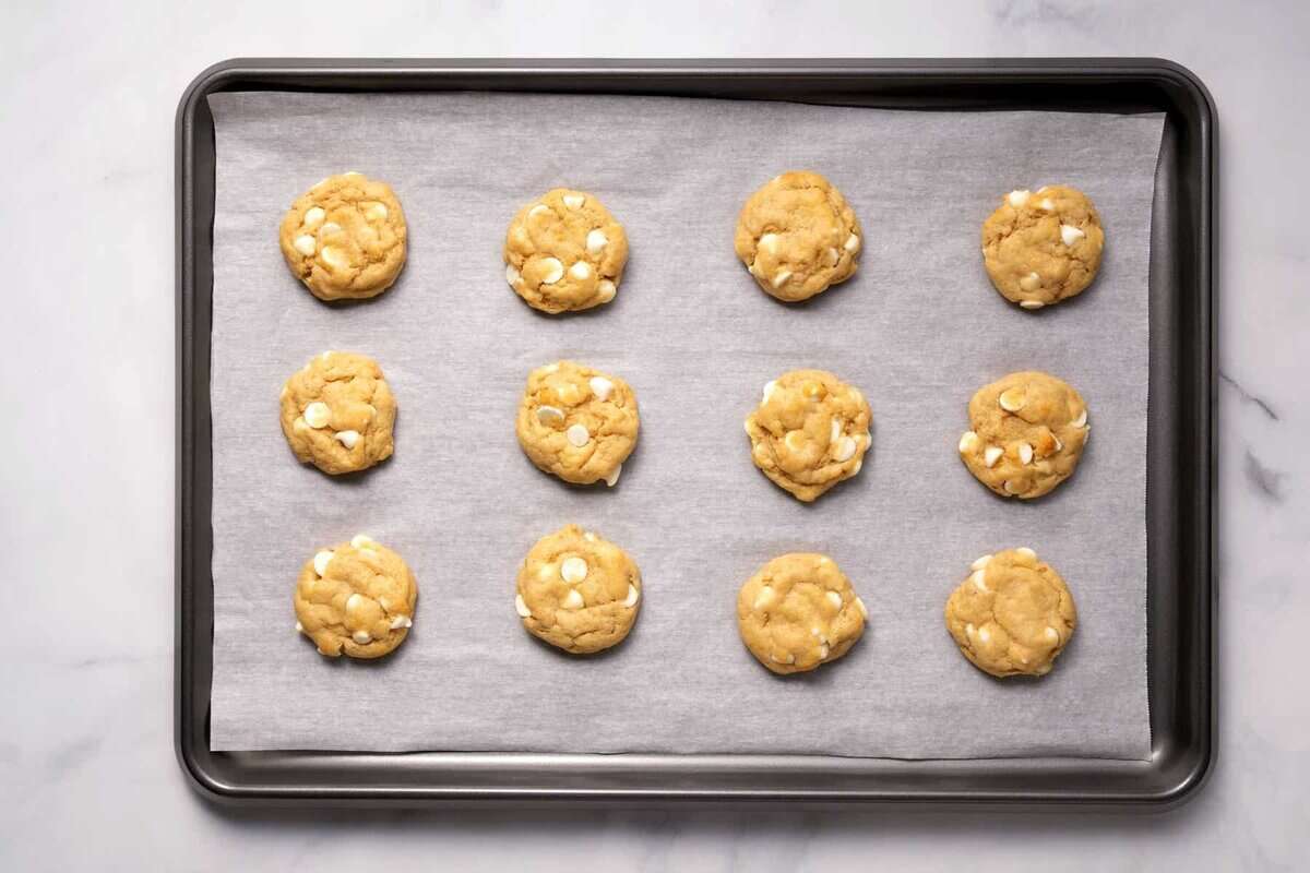 Banana pudding cookies on parchment lined baking sheet.