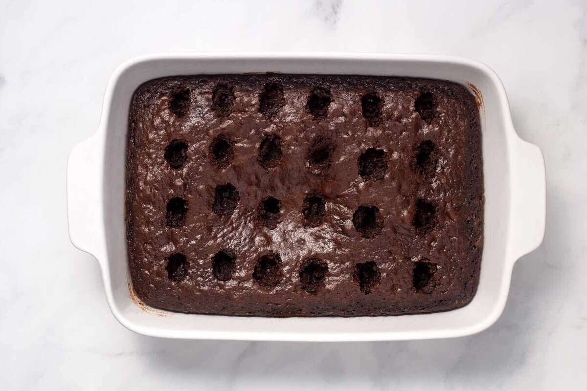Holes poked into chocolate cake.