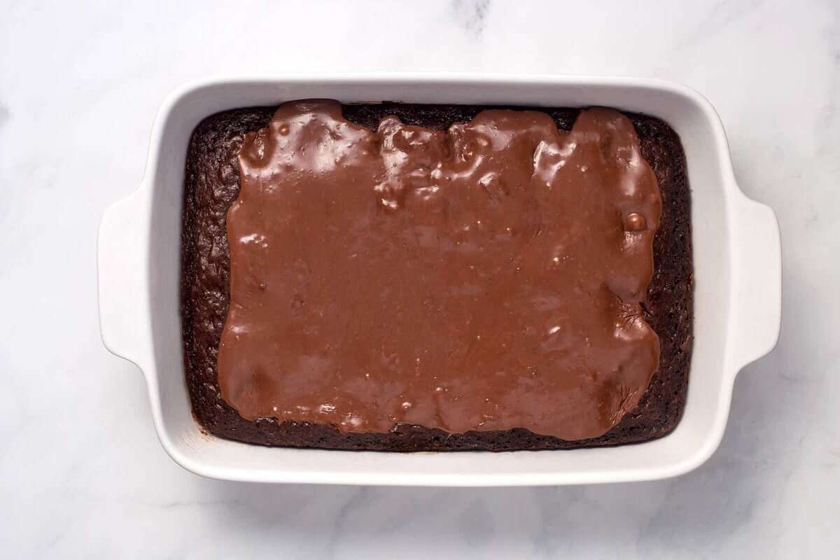 Chocolate condensed milk filling spread over chocolate cake.