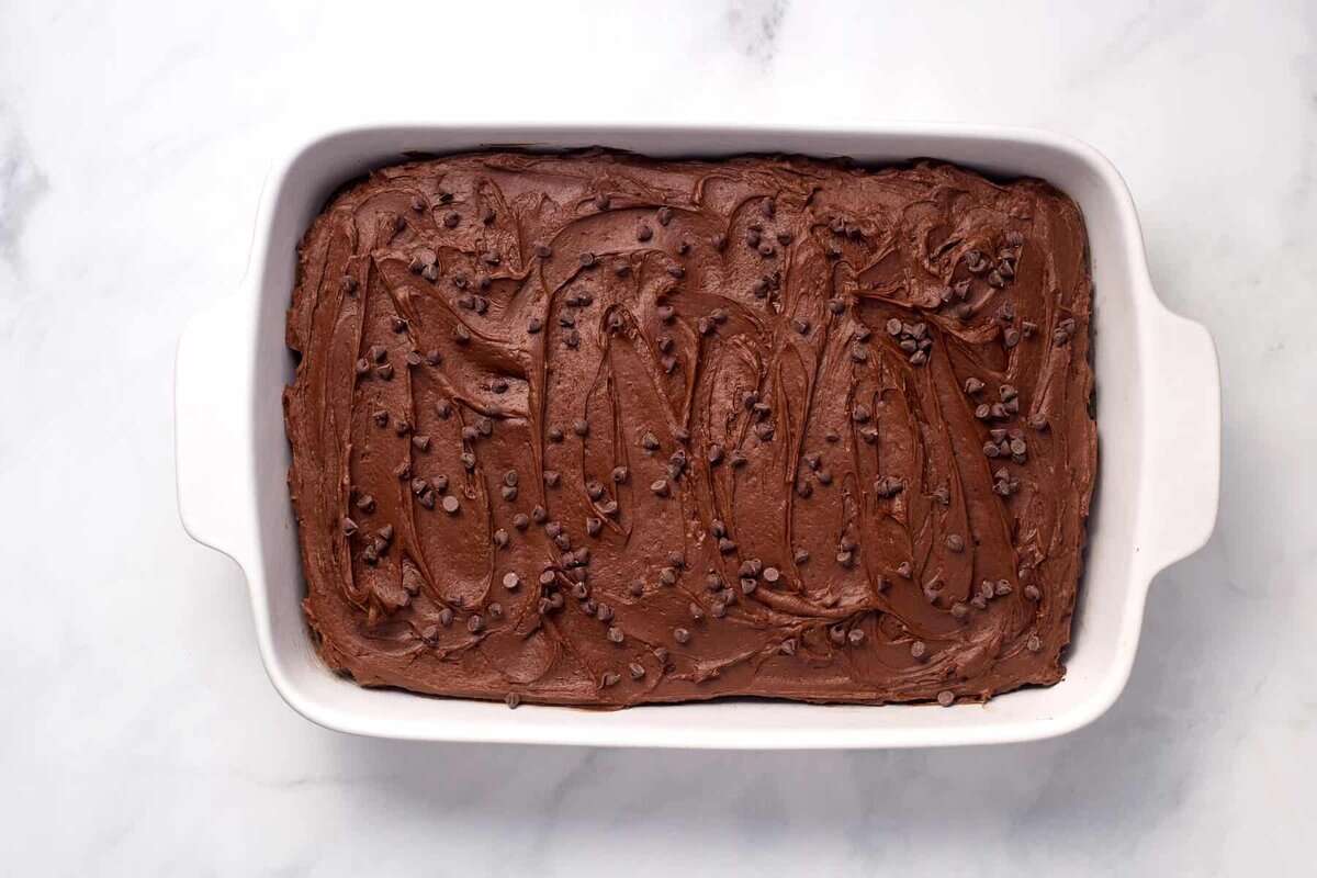 Frosted chocolate poke cake in pan.