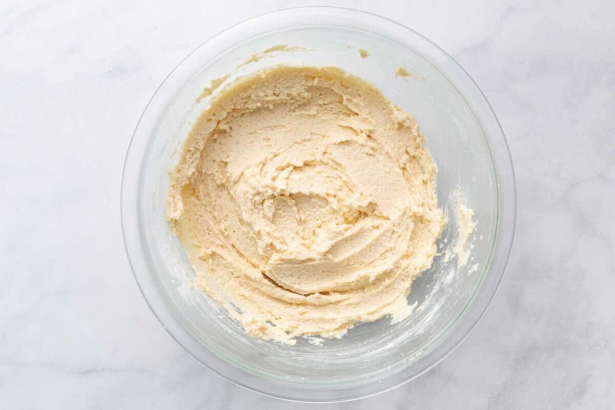 Butter and sugar creamed together in a glass bowl.