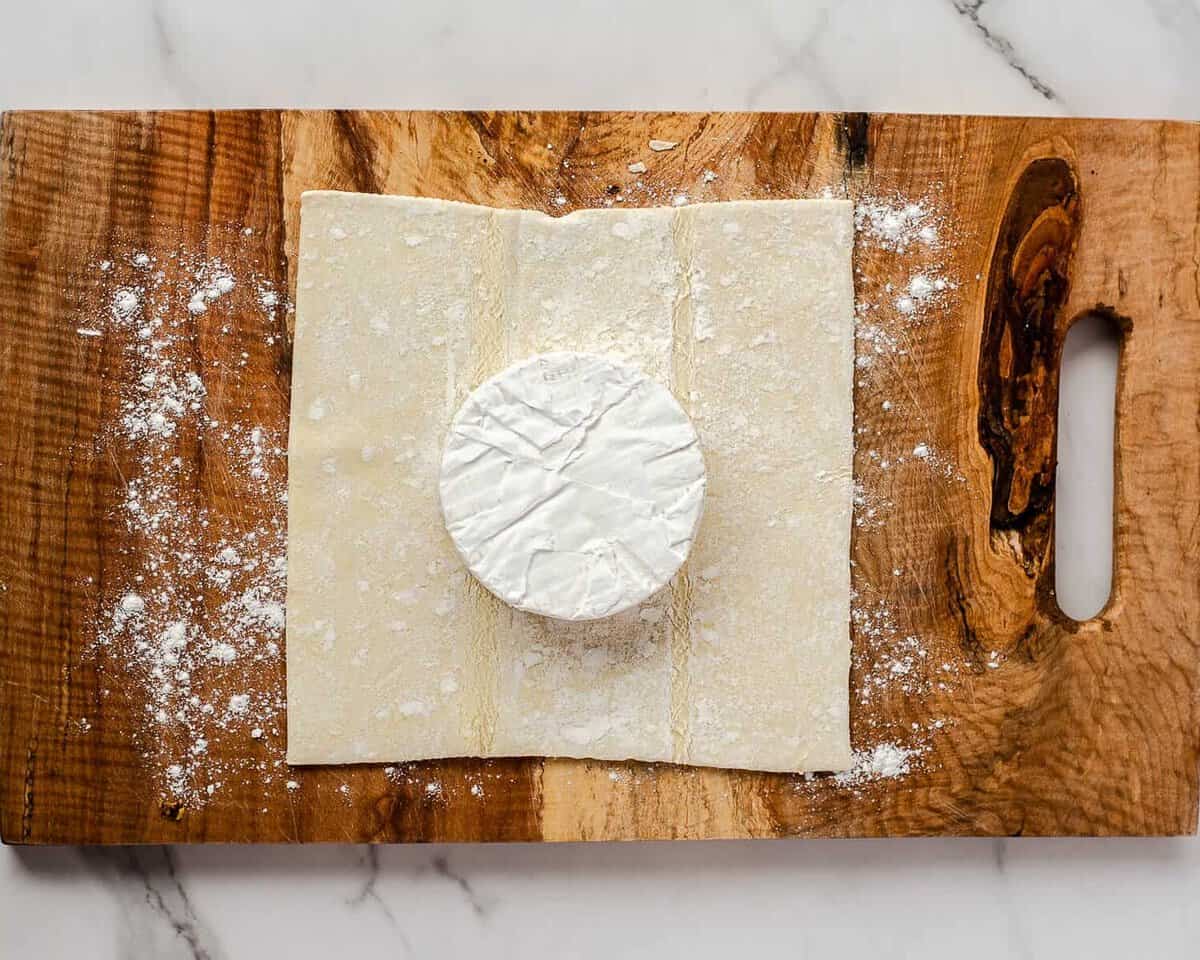 Wheel of brie on sheet of puff pastry.
