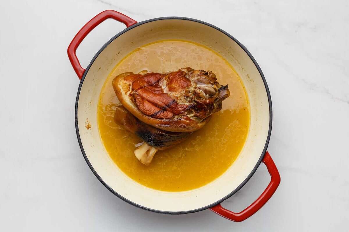 Ham hocks in a white Dutch oven. 