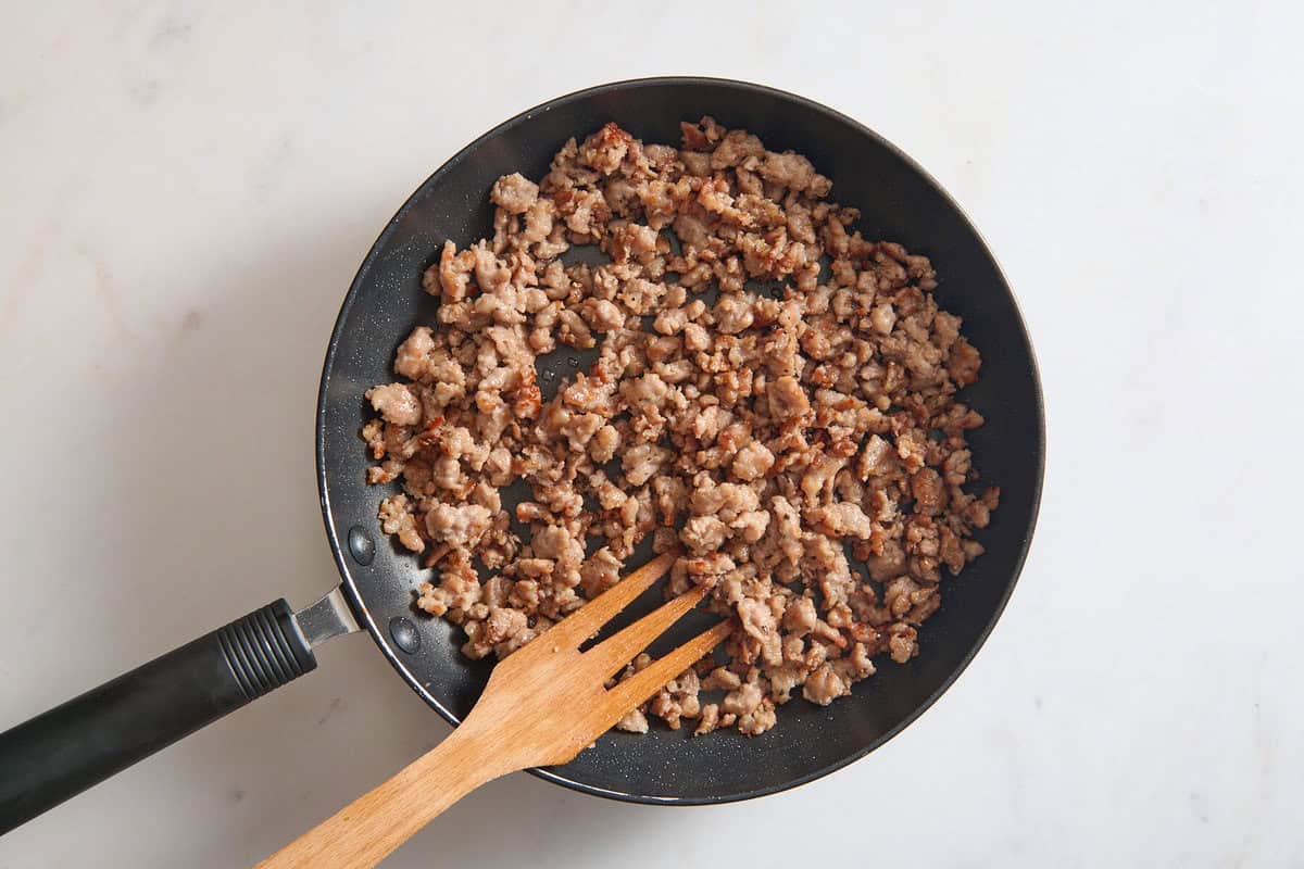 Sausage browning in skillet.