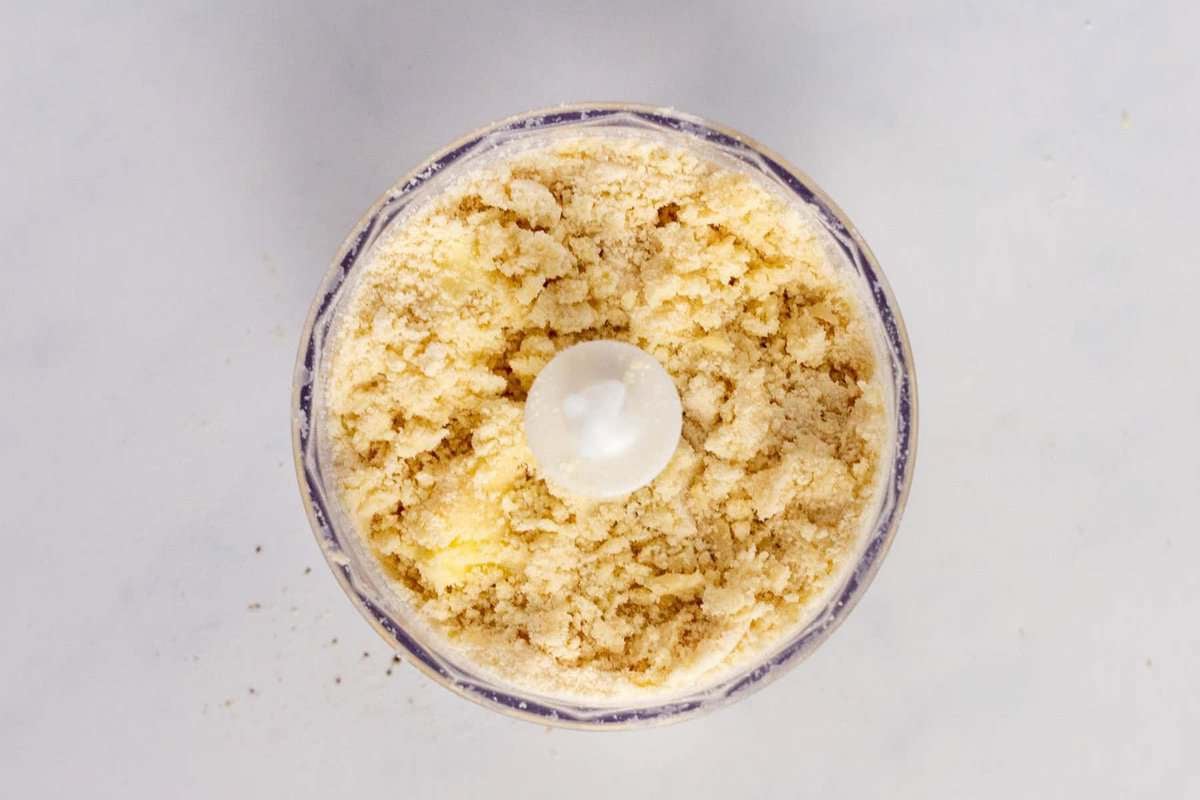 Butter and dry ingredients combined in food processor to form coarse meal.