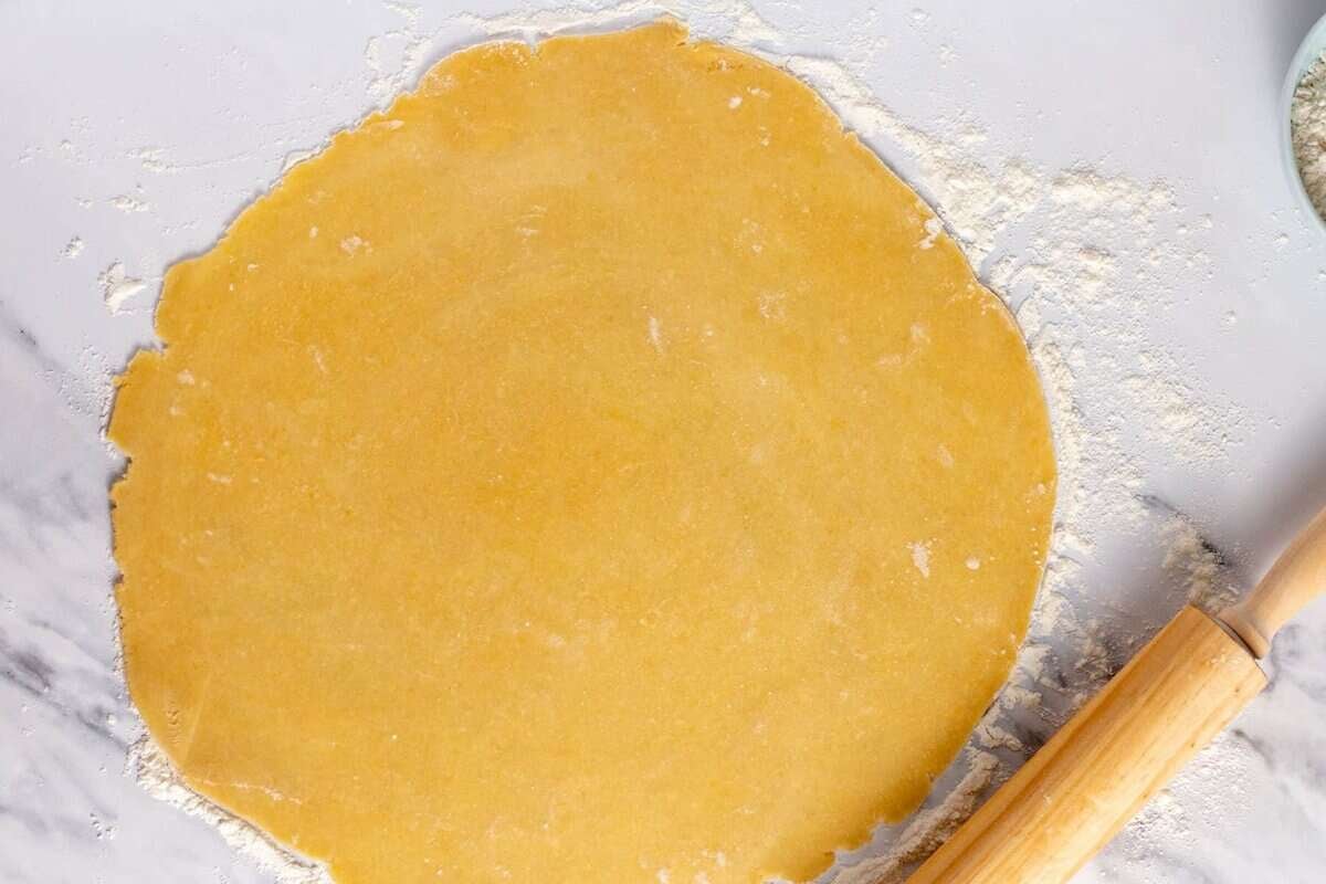 Rolled out pie crust dough on floured work surface.