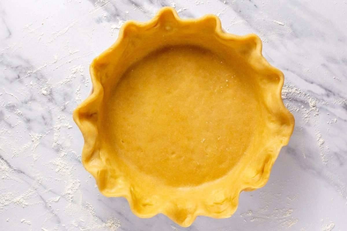 Pie crust fluted in pan before baking.