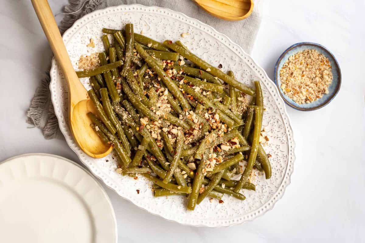 String beans on platter with chopped almonds.