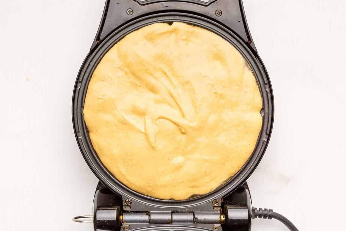 Sweet potato waffle batter in a waffle maker. 
