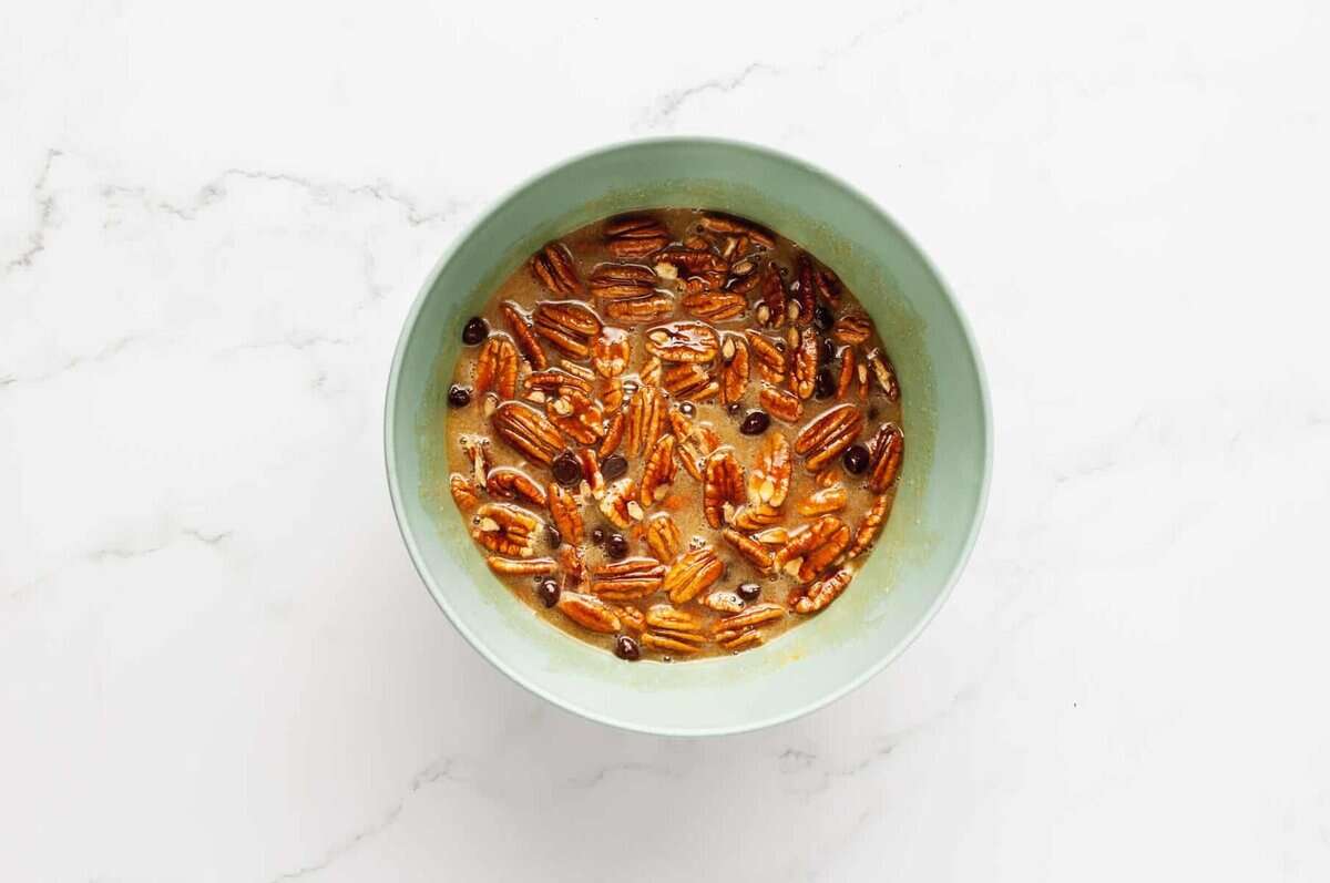 Chocolate pecan pie filling in mixing bowl.