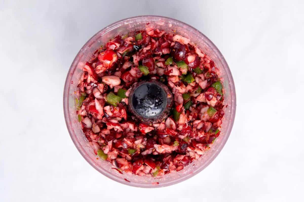 Cranberry jalapeño topping mixture in food processor.