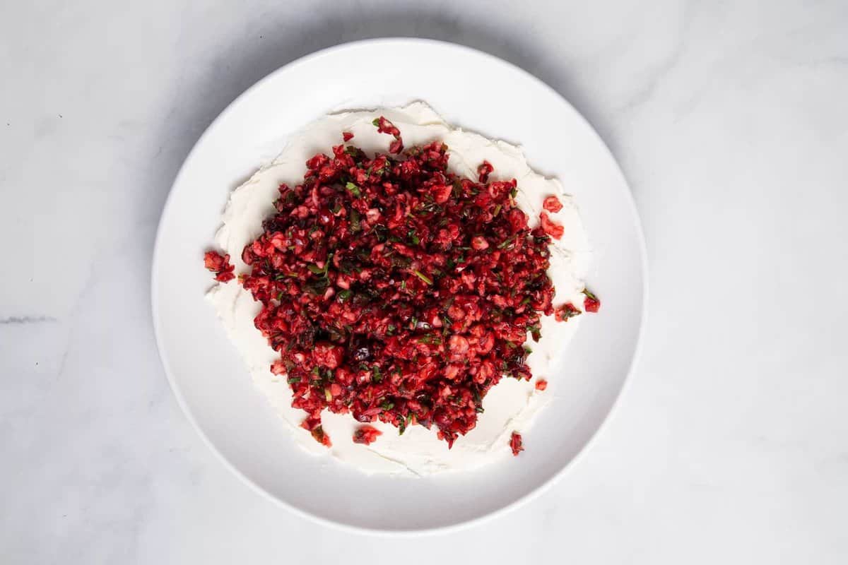 Cranberry jalapeño dip with cream cheese on plate.