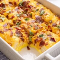 Bacon, egg and cheese biscuit casserole in casserole dish with one slice removed.