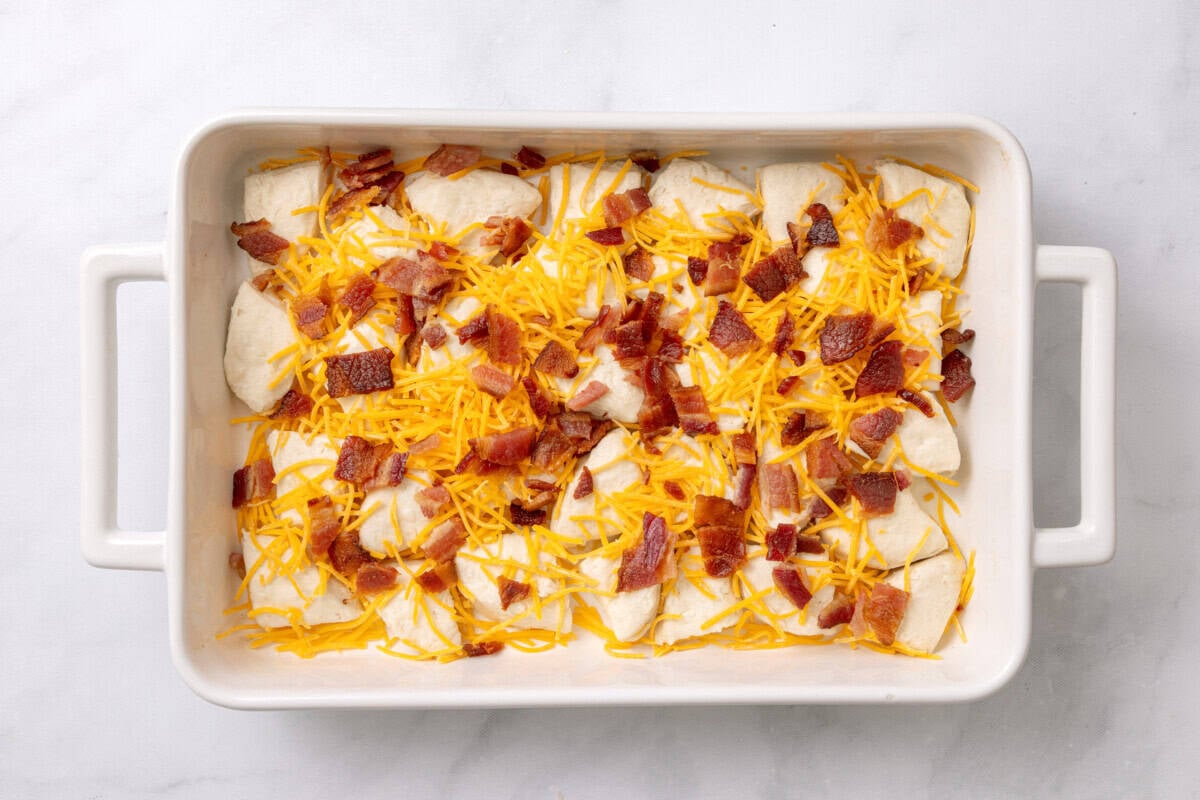 Cheese and bacon added to casserole dish for breakfast bake.