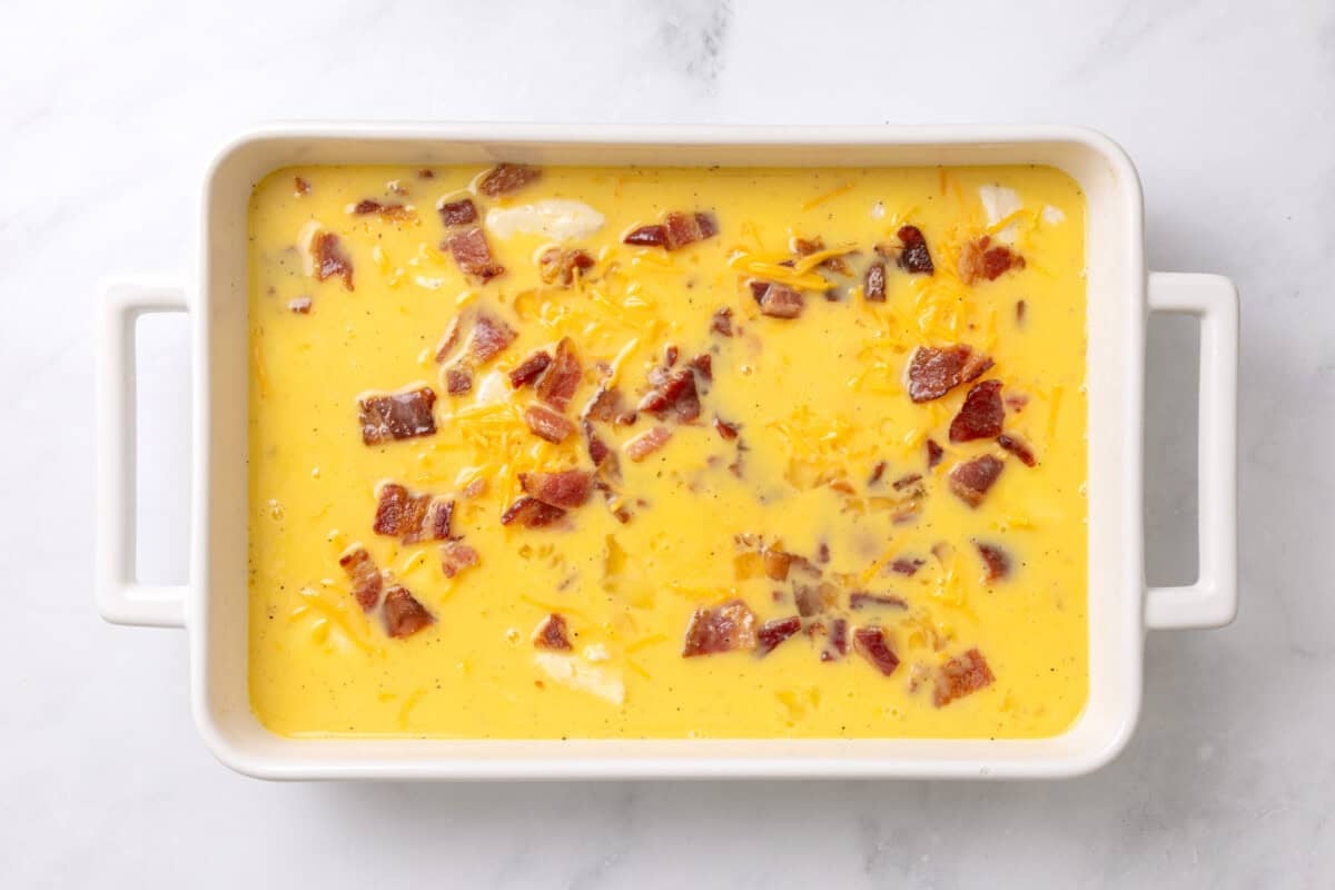 Bacon and egg added to casserole dish.