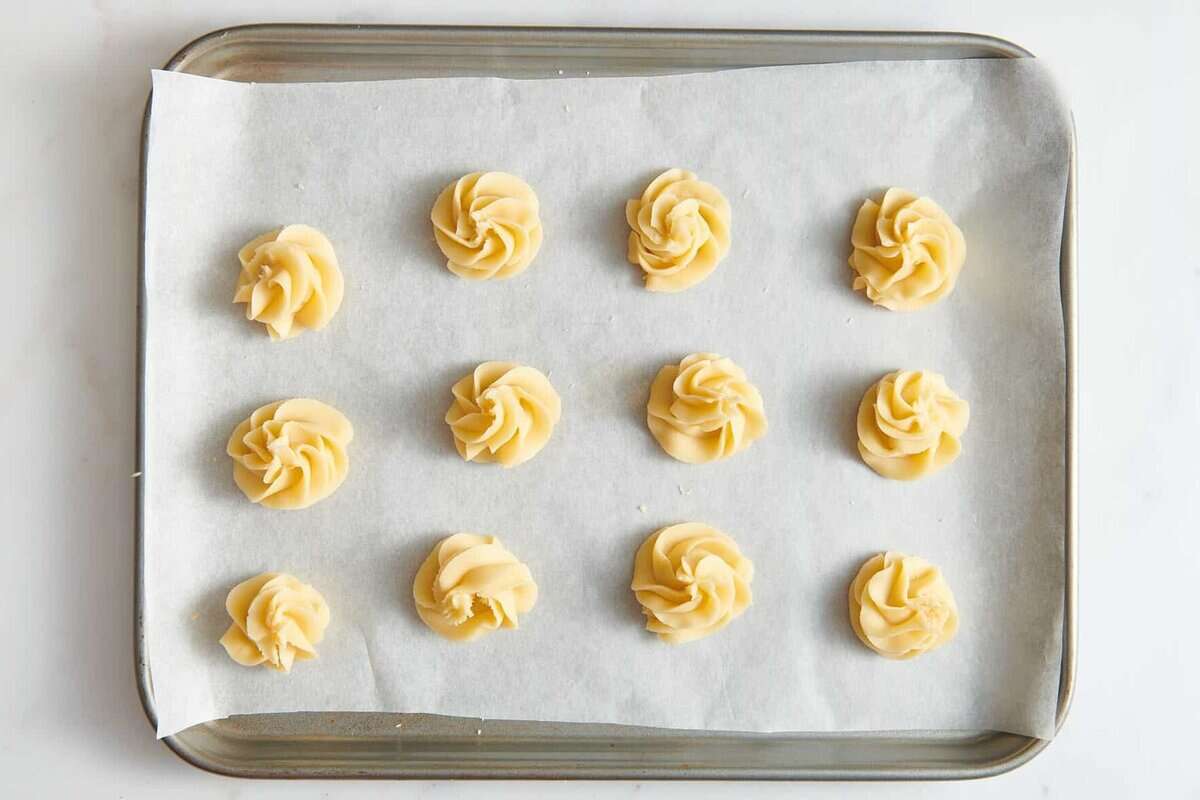 Christmas butter cookies on parchment lined baking sheet before baking.