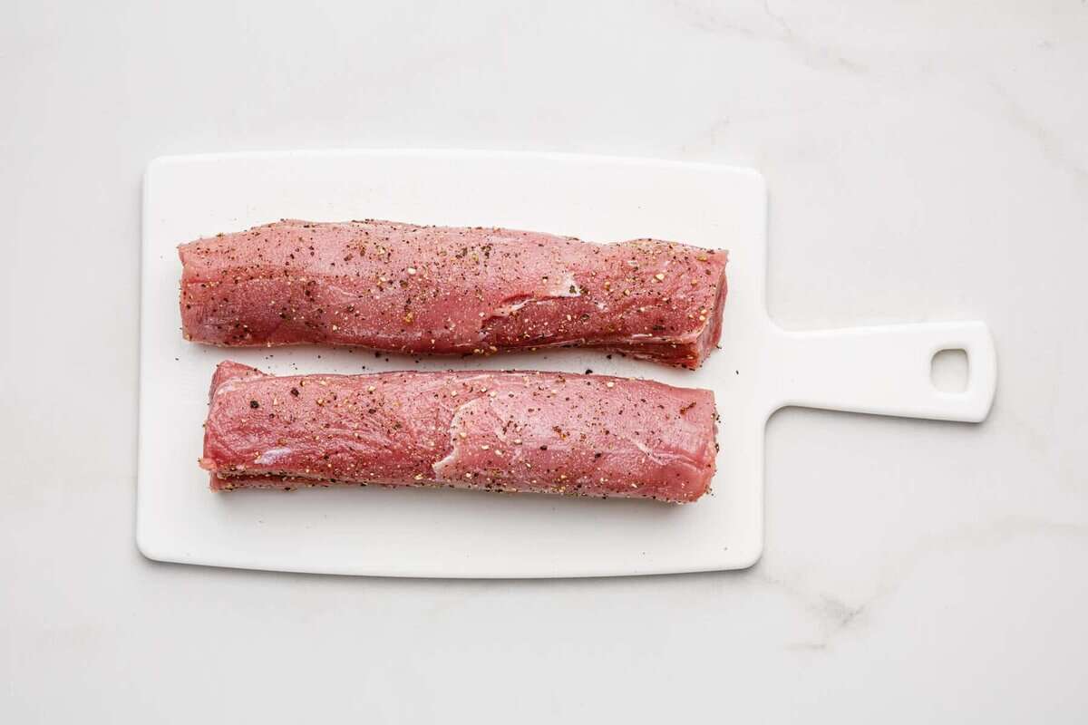 Two pork tenderloins on cutting board.