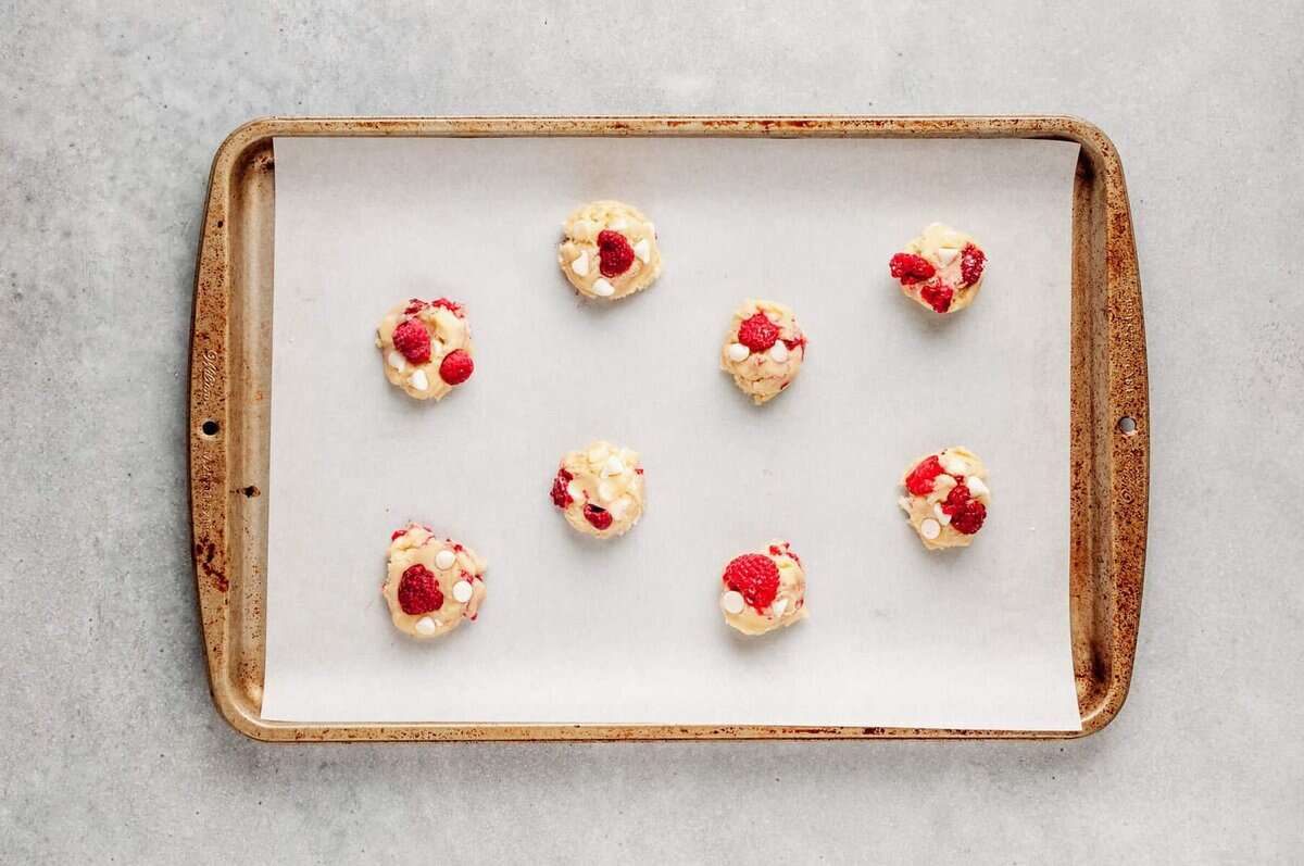 White chocolate and raspberry cookies on sheet pan before baking.