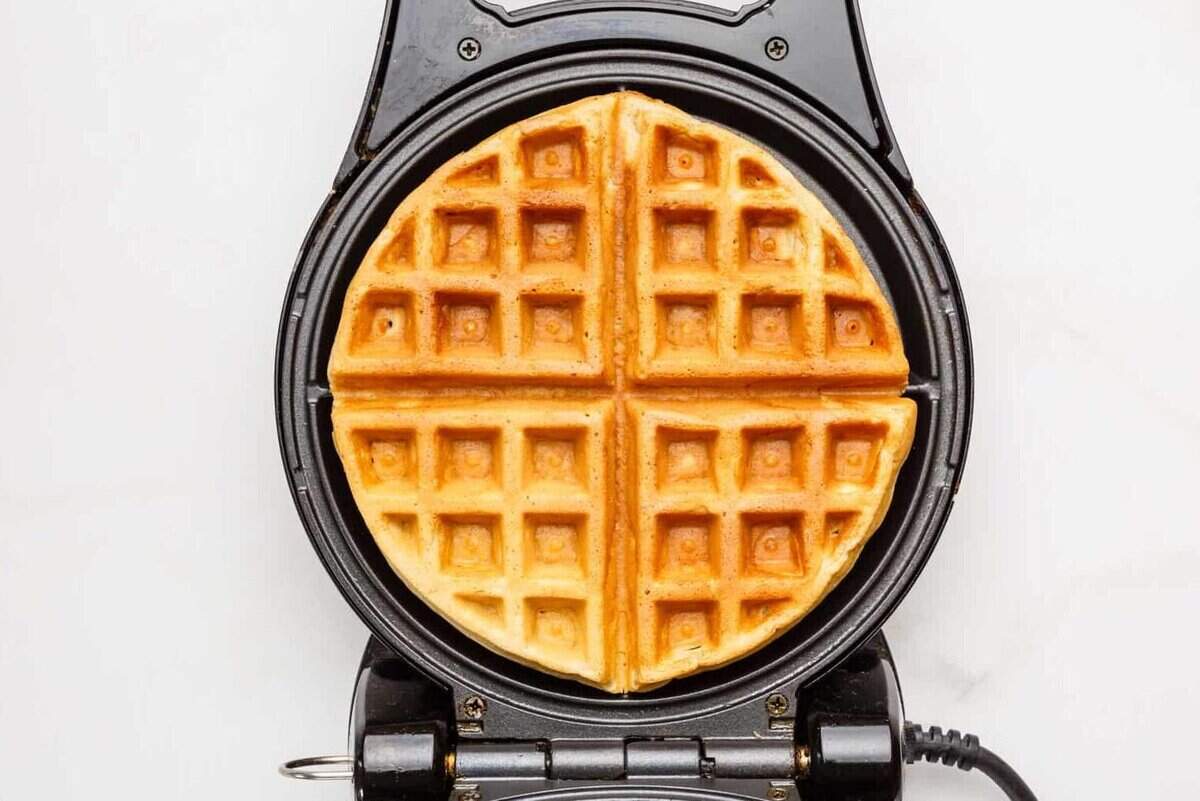 A cooked waffle in a waffle iron.