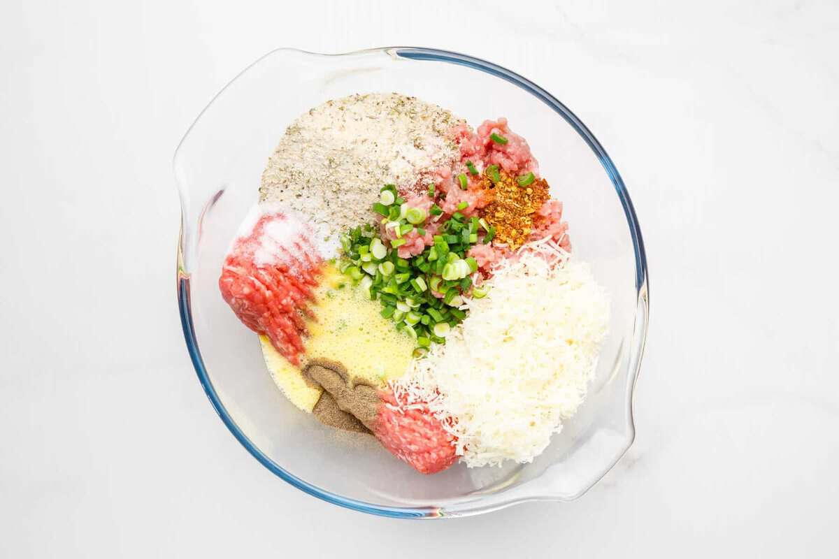 Ingredients for air fryer meatballs in glass bowl.