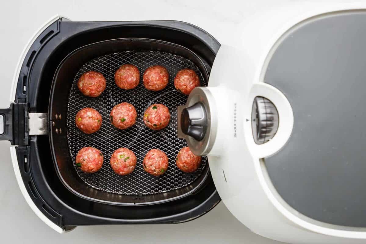 Meatballs in air fryer basket.