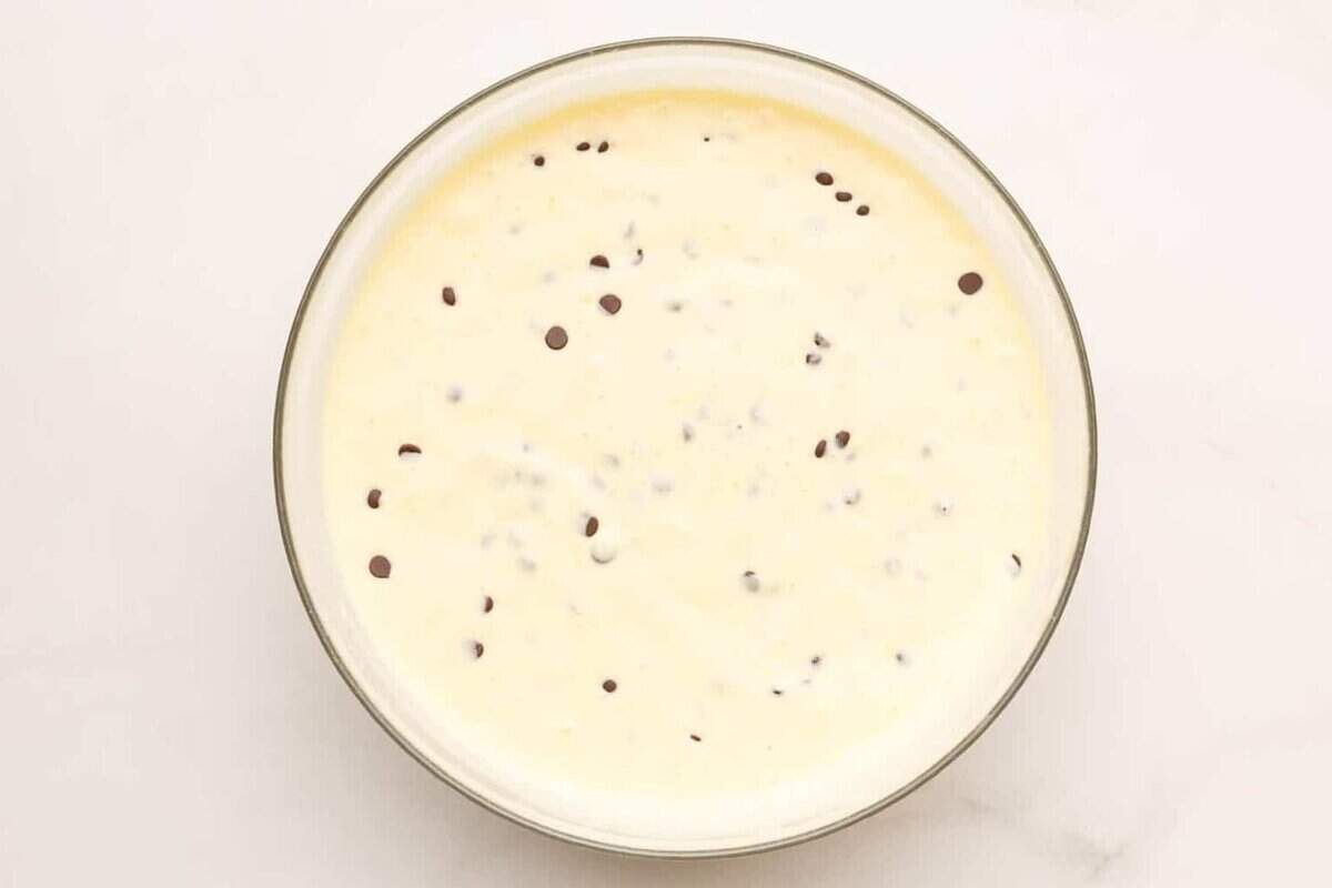 Chocolate chip waffle batter in glass mixing bowl.